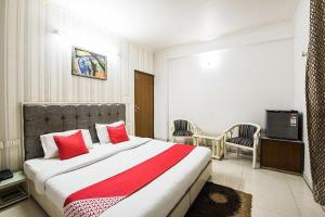 a hotel room with a large bed with red pillows at Hotel Silver Leaf, Noida in Noida