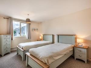 BrundallにあるSunset Lodgeのベッドルーム1室(ベッド2台、窓付)