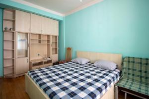 um quarto com uma cama com uma parede azul em Funicular Apartments em Tbilisi