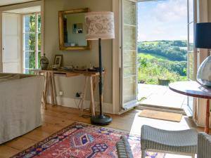 a living room with a floor lamp and an open door at The Old Vicarage in Helford