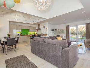 a living room with a gray couch and a kitchen at Woodend Barn in Auchterarder