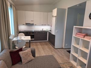 a living room with a couch and a kitchen at Apartment Songhill in Kuopio