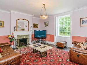 a living room with a couch and a tv at Lode Hall in Upwell