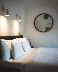 a bedroom with a bed with white pillows and a mirror at Domeček / Tiny House in Český Krumlov