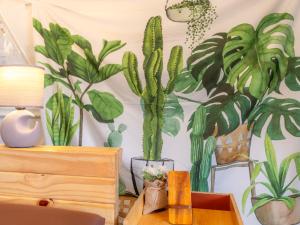 een kamer met een muur met planten erop bij Phu Morinn Cafe&Camping in Mon Jam