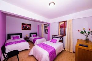 a purple bedroom with two beds and a dresser at Mallmanya Inn in Cusco
