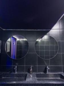 two mirrors above two sinks in a public bathroom at Crypto Hostel in Almaty