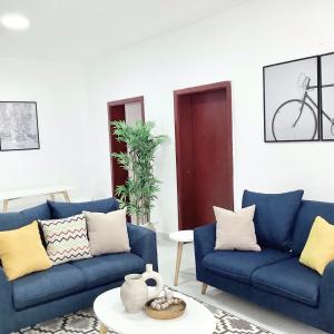 a living room with two blue couches and a table at Lekki FootPrint, Lekki Phase1 in Lekki