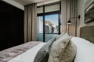1 dormitorio con 1 cama y ventana grande en The Carrington Top Floor Luxury Apartment, en Ciudad del Cabo