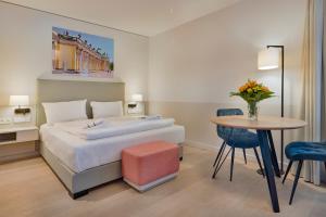 ein Hotelzimmer mit einem Bett und einem Tisch in der Unterkunft Elisapart - Apartments am Sommerschloss in Potsdam