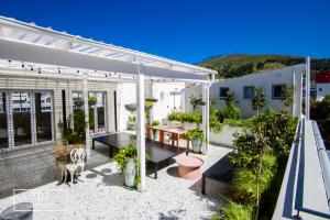 un patio con plantas y una pérgola blanca en The Carrington Top Floor Luxury Apartment, en Ciudad del Cabo