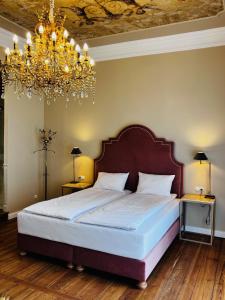 Un dormitorio con una cama grande y una lámpara de araña. en Willa Berlińska - pokoje ,restauracja 