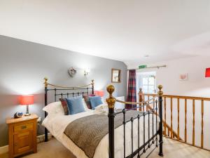 a bedroom with a bed with blue pillows at Cove View Cottage in Malham