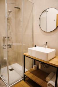a bathroom with a sink and a shower at PATE'O Hostel & Suites in Ovar