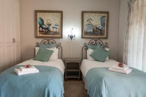 巴莉斯的住宿－Mistique Waters Guesthouse，蓝色和绿色的客房内的两张床