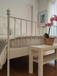 - une chambre avec un lit blanc, une table et des fleurs dans l'établissement Green Day, à Athènes