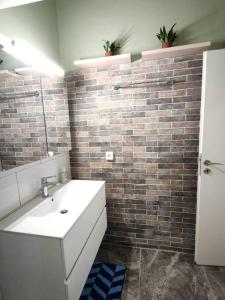 La salle de bains est pourvue d'un lavabo et d'un mur en briques. dans l'établissement Green Day, à Athènes