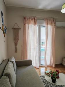 - un salon avec un canapé et une grande fenêtre dans l'établissement Green Day, à Athènes