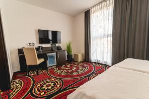 Habitación de hotel con cama y TV de pantalla plana. en Casino & Hotel ADMIRAL Ptuj, en Ptuj