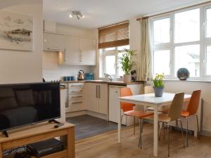 a kitchen and dining room with a table and a tv at The Nook in Woolacombe
