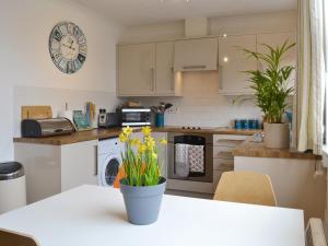 a kitchen with a table with yellow flowers on it at The Nook in Woolacombe