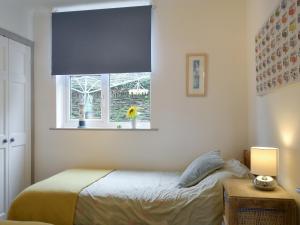 1 dormitorio con cama y ventana en The Nook, en Woolacombe