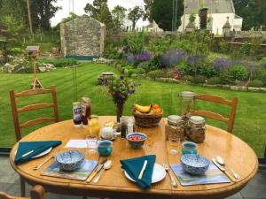a wooden table with food on it in a garden at The Old School, Kingussie in Kingussie