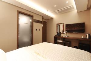 釜山にあるHotel MoMoのベッドルーム(ベッド1台、デスク、テレビ付)
