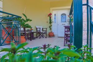a patio with chairs and a table and a door at Villa Theano - Family House in Lixouri, Kefalonia in Lixouri