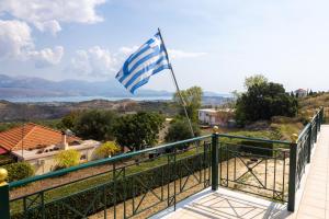 a flag flying on top of a balcony with a view at Villa Theano - Family House in Lixouri, Kefalonia in Lixouri