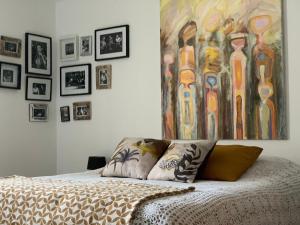 1 dormitorio con 1 cama con una pintura en la pared en Bocage et Coquillage, en Gouville-sur-Mer