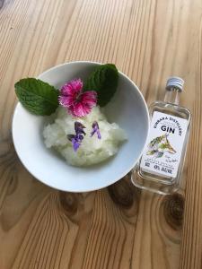 a bowl of rice with a flower and a bottle of gin at The Old School, Kingussie in Kingussie