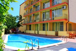 a building with a swimming pool in front of a building at Ryor Hotel - Restaurant & Free Parking in Sunny Beach