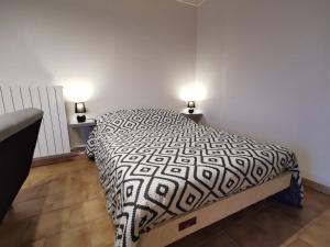 a bedroom with a bed with a black and white comforter at Studio Campan in Armentieux