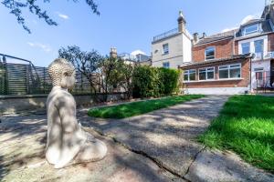 une statue d'une femme assise dans une allée dans l'établissement Fantastic 2BR flat wpriv Gdn, Crouch End, à Londres