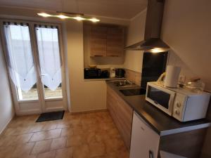 a small kitchen with a microwave on a counter at Studio Campan in Armentieux