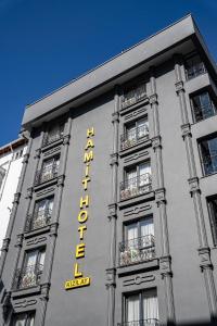 a building with a yellow sign on the side of it at Hamit Hotel Kizilay in Ankara