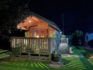 a small cabin with a fence and stairs at night at The Firkin Lodge in Whaplode