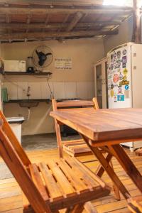 a table and chairs in a kitchen with a refrigerator at Villa Residencial Encantos Da Mata in Itacaré