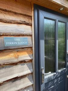 um sinal na lateral de um edifício com uma porta em The Firkin Lodge em Whaplode