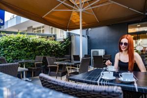 a woman sitting at a table with a cup of coffee at Hamit Hotel Kizilay in Ankara