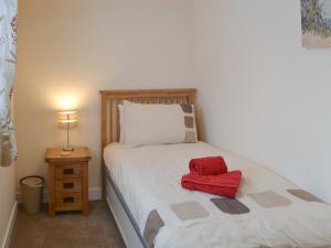 Knights Den في بورت إيزاك: غرفة نوم بسرير عليه غرض احمر