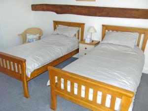 dos camas sentadas una al lado de la otra en un dormitorio en Red Barn Cottage, en Kettleburgh