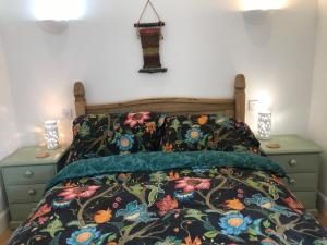 a bedroom with a bed with a floral bedspread and two night stands at The Old School, Kingussie in Kingussie