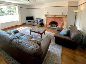 a living room with two couches and a fireplace at Penfound Country Cottage in Poundstock