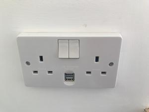 a white light switch on a white wall at The Old School, Kingussie in Kingussie