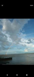 un arco iris en el cielo sobre un cuerpo de agua en Home Puerto carreño vichada, en Cerro el Bita