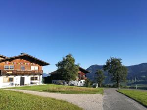 una strada che conduce a una casa con montagne sullo sfondo di Ferienwohnung Bärfeld a Fieberbrunn