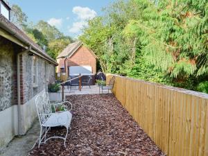 a backyard with a fence and chairs and a table at Whatley Lodge in Winsham