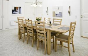 een eetkamer met een houten tafel en stoelen bij 4 Bedroom Gorgeous Home In Tarm in Hemmet
